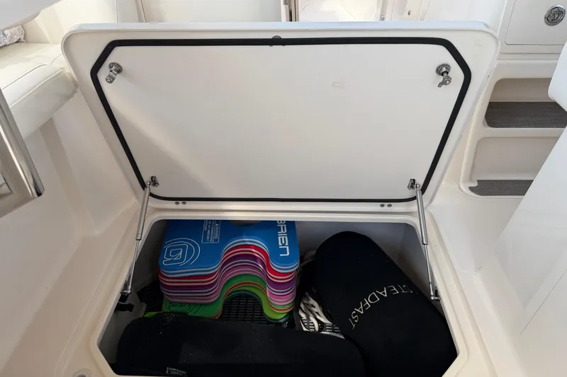 Slide: The Image of Storage compartment on a 2017 Grady-White Freedom 335 boat, containing colorful water sports gear. - 34