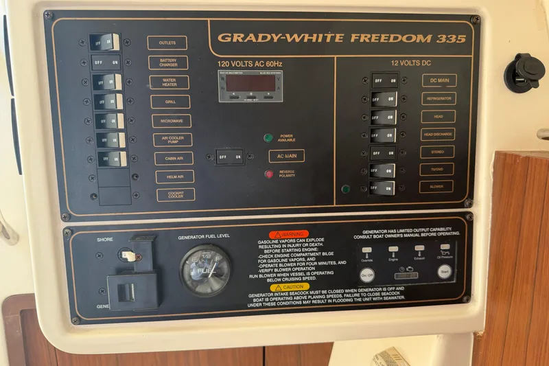 Slide: The Image of Control panel of a 2017 Grady-White Freedom 335 boat, featuring various switches and gauges. - 39