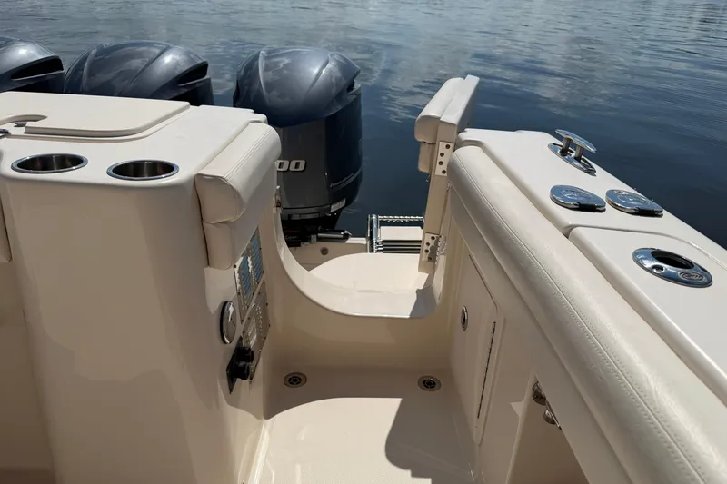 Slide: The Image of 2017 Grady-White Freedom 335 boat interior with triple outboard engines on calm water. - 49
