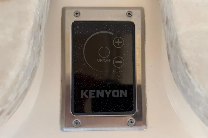 Slide: The Image of Kenyon control panel on 2017 Grady-White Freedom 335 boat, featuring on/off and adjustment buttons. - 53