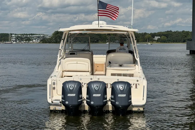 Slide: The Image of 2017 Grady-White Freedom 335 boat with triple Yamaha engines on a calm lake. - 7
