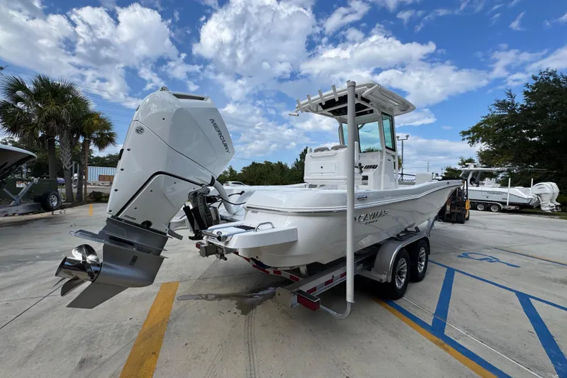 Slide: The Image of 2026 Caymas 28 HB boat on trailer, parked outdoors under a blue sky. - 13