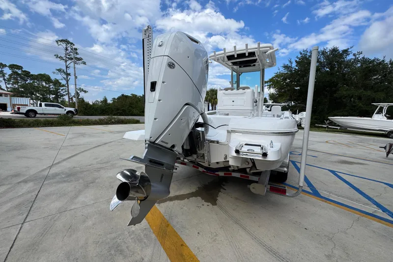Slide: The Image of 2026 Caymas 28 HB boat with powerful outboard motor in a parking lot. - 14