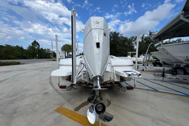 Slide: The Image of 2026 Caymas 28 HB boat with powerful outboard motor, parked on a concrete lot under a blue sky. - 15