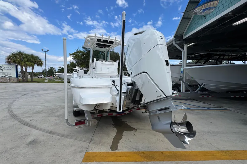 Slide: The Image of 2026 Caymas 28 HB boat with powerful outboard motor, parked at a marina under a blue sky. - 16