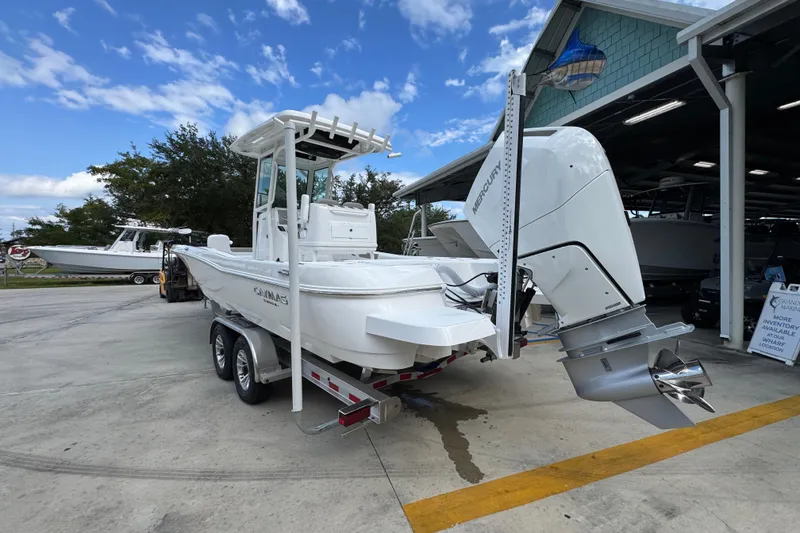 Slide: The Image of 2026 Caymas 28 HB boat on trailer with Mercury outboard motor, parked outdoors. - 17