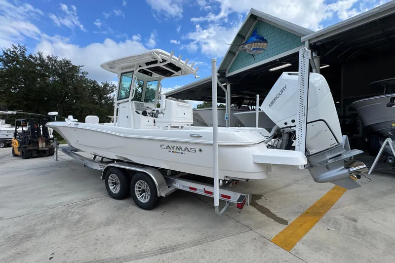 Slide: The Image of 2026 Caymas 28 HB boat on trailer, parked outside a marine facility. - 18
