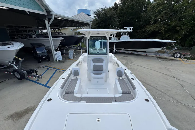 Slide: The Image of 2026 Caymas 28 HB boat with spacious seating, docked at a marina. - 24