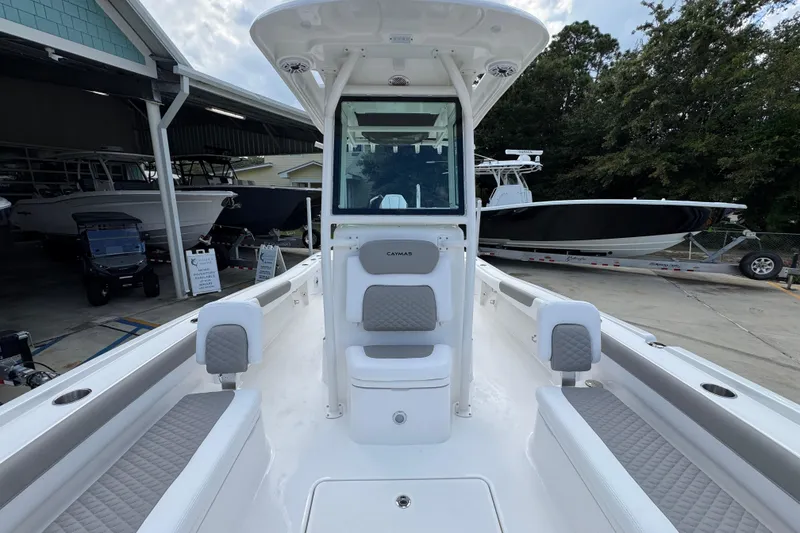 Slide: The Image of 2026 Caymas 28 HB boat interior with seating and console, docked at a marina. - 25