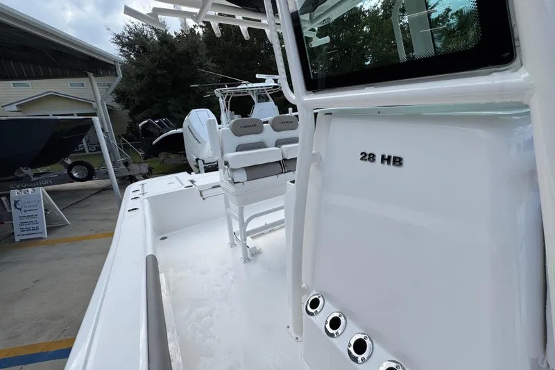 Slide: The Image of 2026 Caymas 28 HB boat with seating and rod holders, displayed outdoors. - 27