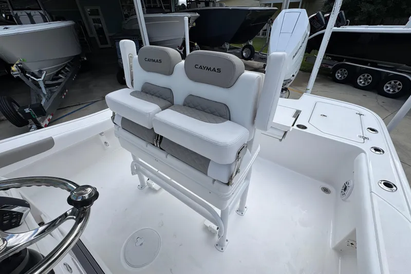 Slide: The Image of 2026 Caymas 28 HB boat interior with cushioned seating and steering wheel. - 29