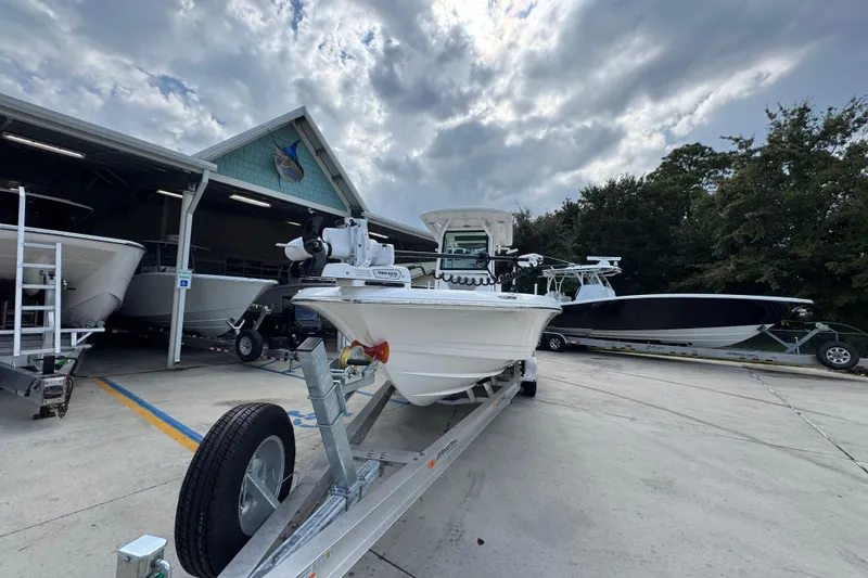 Slide: The Image of 2026 Caymas 28 HB boat on trailer at dealership under cloudy sky. - 6