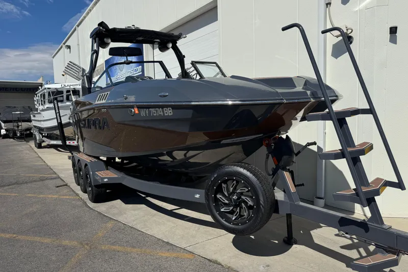 Slide: The Image of 2021 Supra SE 575 boat on trailer, parked outside a building under clear sky. - 3