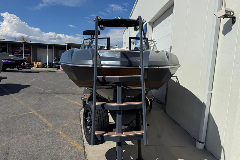 Slide: The Image of 2021 Supra SE 575 boat on trailer, parked outside a service facility under a clear sky. - 4