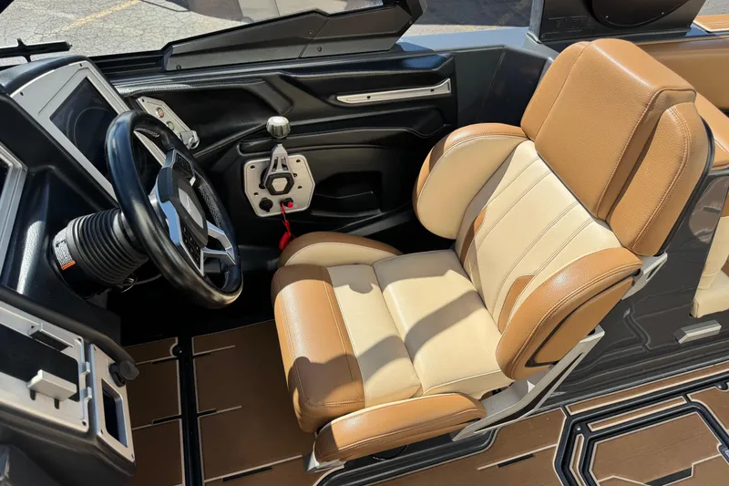 Slide: The Image of 2021 Supra SE 575 boat interior with tan leather seat and steering wheel. - 8