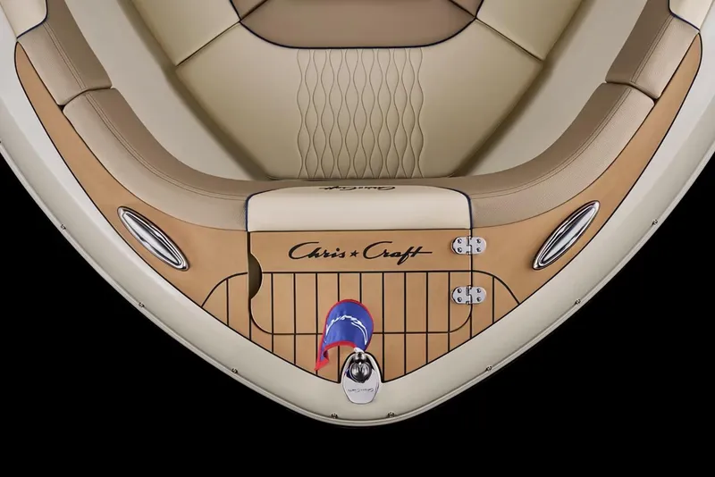 Slide: The Image of 2026 Chris-Craft Sportster 25 boat displayed indoors with American flag. - 4