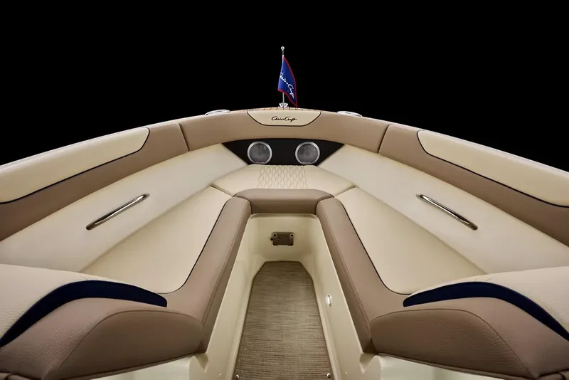 Slide: The Image of 2026 Chris-Craft Sportster 25 boat with elegant seating and American flag, displayed indoors. - 5