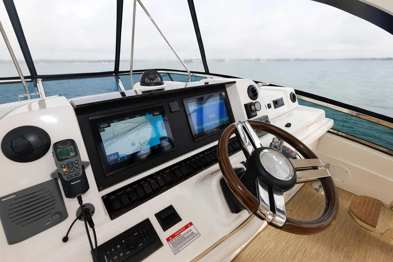 Slide: The Image of Helm of 2010 Sea Ray 520 Sedan Bridge with navigation screens and steering wheel. - 20