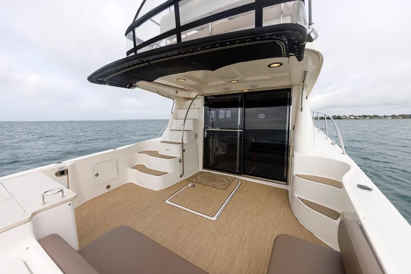 Slide: The Image of 2010 Sea Ray 520 Sedan Bridge yacht deck with ocean view and seating area. - 27