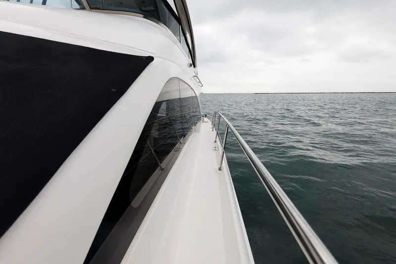 Slide: The Image of 2010 Sea Ray 520 Sedan Bridge yacht cruising on open water under cloudy skies. - 35