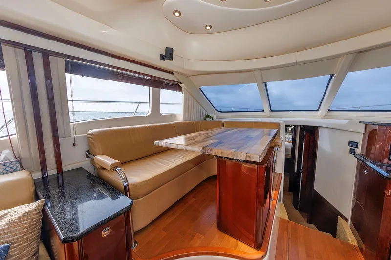 Slide: The Image of Luxurious interior of 2010 Sea Ray 520 Sedan Bridge yacht with elegant seating and panoramic windows. - 38