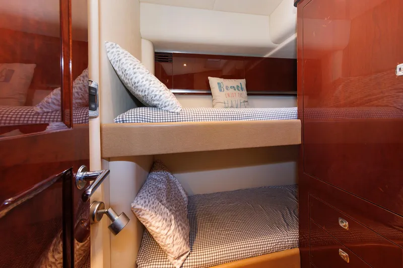 Slide: The Image of Bunk beds in 2010 Sea Ray 520 Sedan Bridge cabin with cozy pillows and wooden cabinetry. - 59