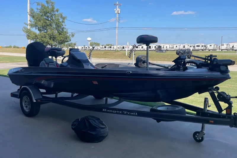Slide: The Image of 2018 Ranger Z185 boat on trailer, parked outdoors under clear blue sky. - 2