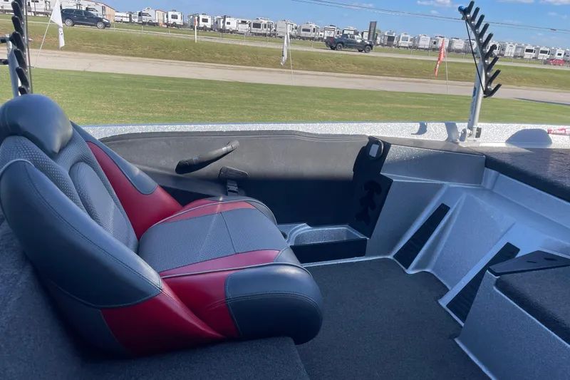 Slide: The Image of 2018 Ranger Z185 boat interior with red and gray seating, parked near RVs. - 4