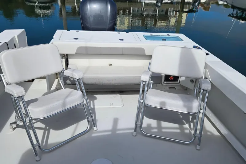 Slide: The Image of 2022 Parker 2520 XLD Sport Cabin boat deck with two white chairs. - 5