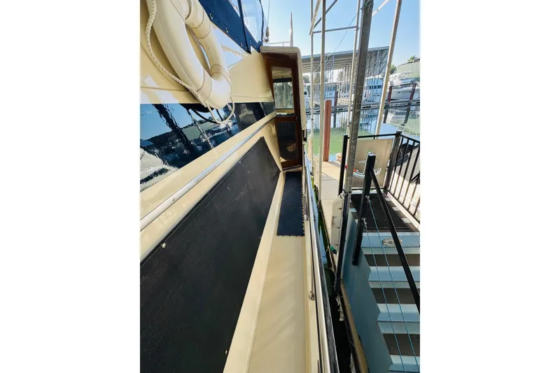 Slide: The Image of 1986 Californian 48 Motor Yacht docked, showing side deck and marina view. - 12