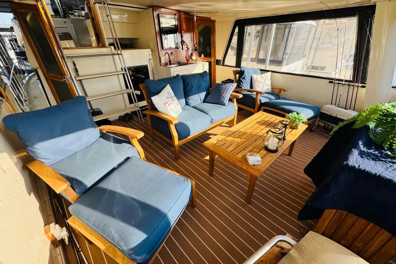 Slide: The Image of Interior of 1986 Californian 48 Motor Yacht with cozy seating and wooden table. - 17
