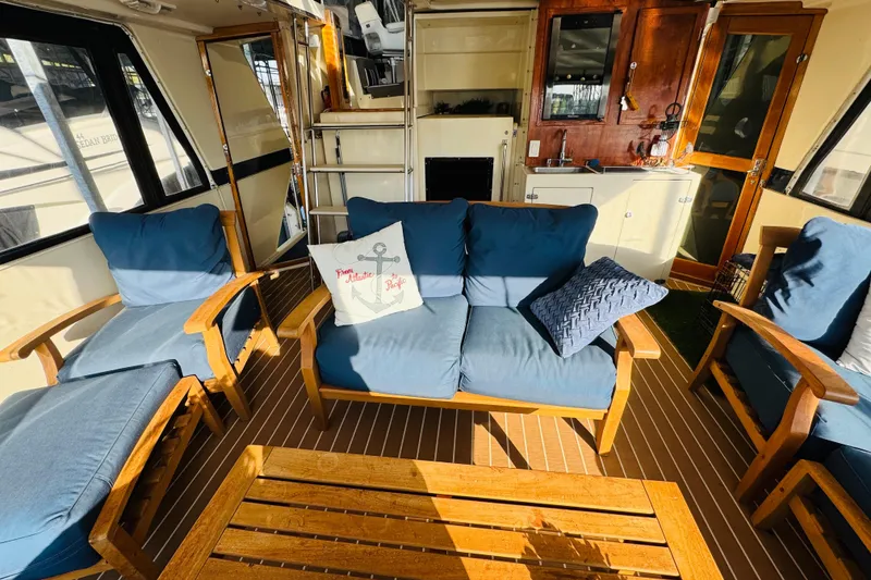 Slide: The Image of Interior of 1986 Californian 48 Motor Yacht with blue cushioned seating and wooden furniture. - 19