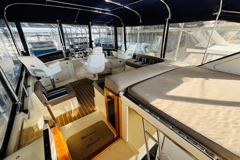 Slide: The Image of 1986 Californian 48 Motor Yacht interior with helm, seating, and welcome mat. - 23