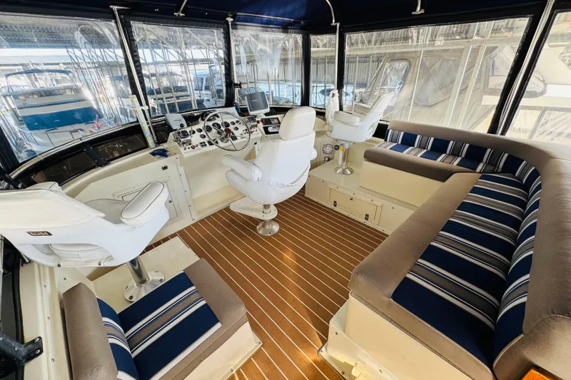 Slide: The Image of 1986 Californian 48 Motor Yacht interior with striped seating and modern helm controls. - 24