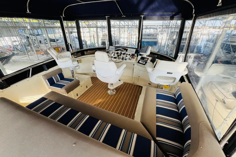 Slide: The Image of 1986 Californian 48 Motor Yacht interior with striped seating and modern navigation equipment. - 25