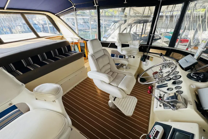 Slide: The Image of 1986 Californian 48 Motor Yacht helm with plush seating and modern controls. - 27