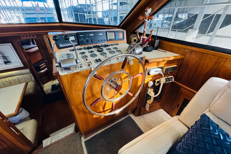 Slide: The Image of 1986 Californian 48 Motor Yacht helm with classic wooden steering wheel and navigation controls. - 43