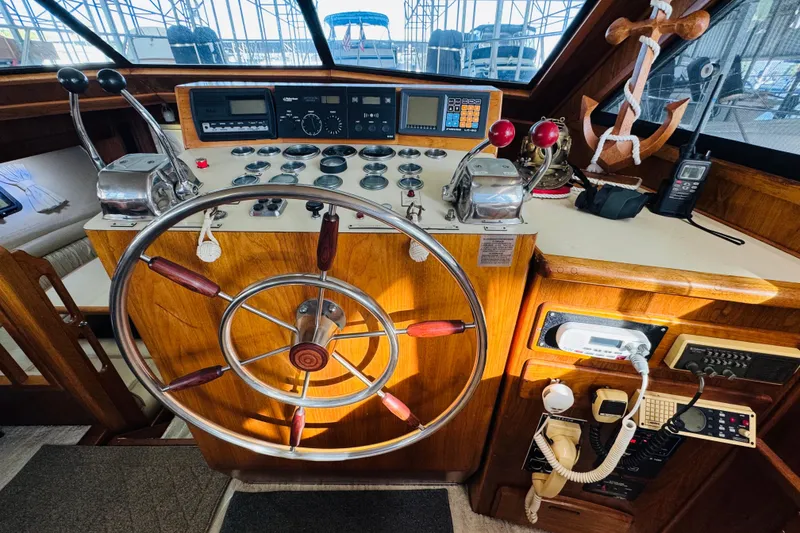 Slide: The Image of 1986 Californian 48 Motor Yacht helm with wooden wheel and navigation controls. - 44