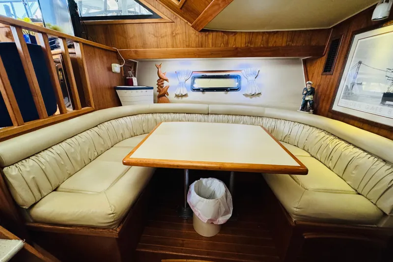 Slide: The Image of 1986 Californian 48 Motor Yacht interior with cozy dining area and wooden accents. - 46