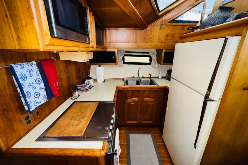 Slide: The Image of 1986 Californian 48 Motor Yacht kitchen with wood cabinetry, dual sinks, and modern appliances. - 48