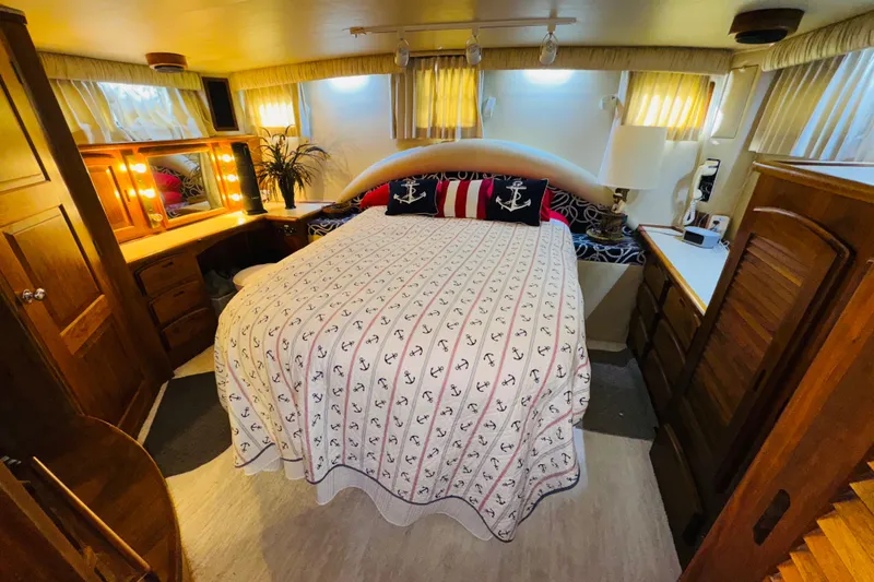 Slide: The Image of Cozy bedroom in 1986 Californian 48 Motor Yacht with nautical-themed decor and warm lighting. - 53