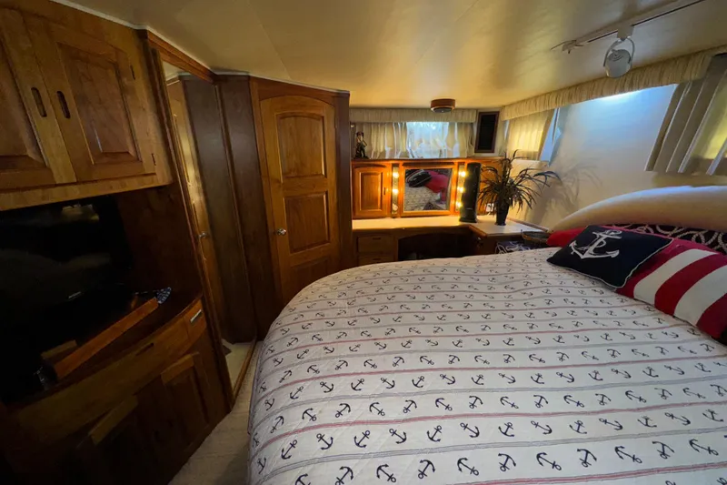 Slide: The Image of Cozy bedroom interior of 1986 Californian 48 Motor Yacht with nautical-themed bedding. - 54
