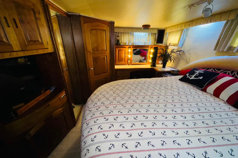 Slide: The Image of Cozy bedroom in 1986 Californian 48 Motor Yacht with nautical decor and wooden furnishings. - 55