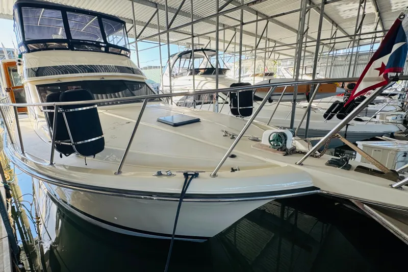 Slide: The Image of 1986 Californian 48 Motor Yacht docked in a marina, featuring sleek design and spacious deck. - 6
