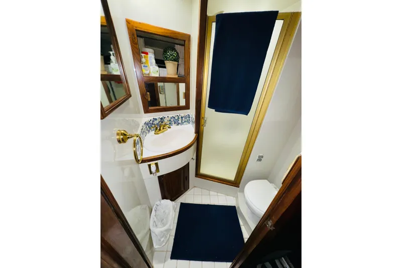 Slide: The Image of Bathroom interior of 1986 Californian 48 Motor Yacht with gold fixtures and blue accents. - 66