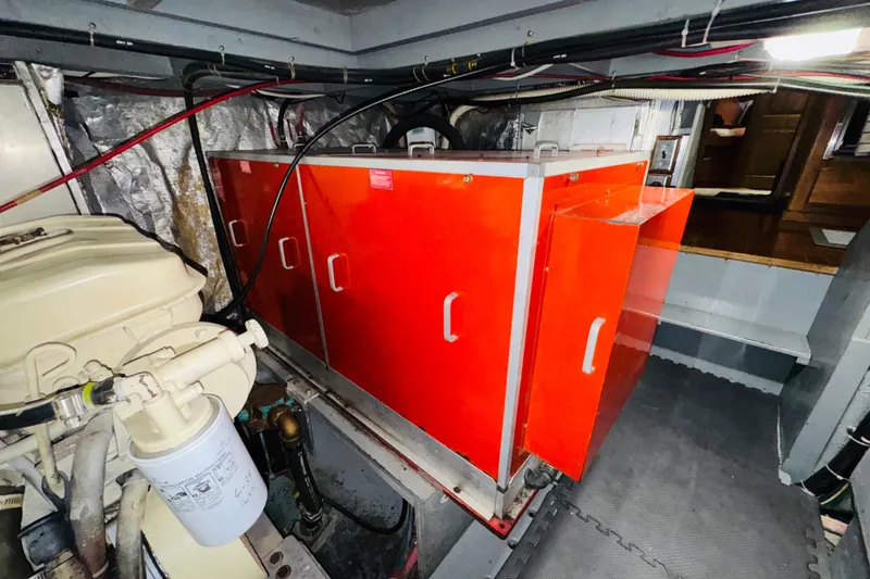 Slide: The Image of Engine room of 1986 Californian 48 Motor Yacht with red storage cabinets. - 74