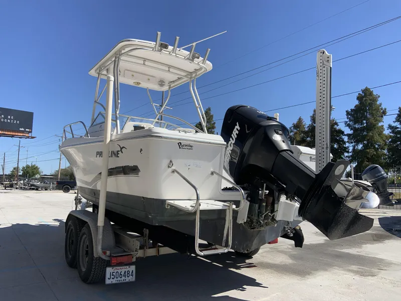 Slide: The Image of 2007 Pro-Line 21 Walk boat on trailer with Mercury outboard motor, parked outdoors. - 13