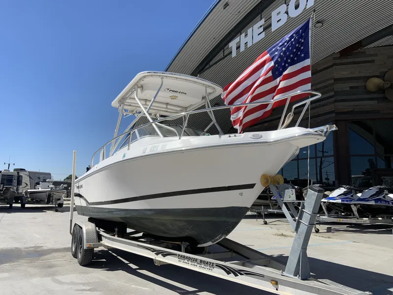 Slide: The Image of 2007 Pro-Line 21 Walk boat on trailer with American flag, parked outside dealership. - 3