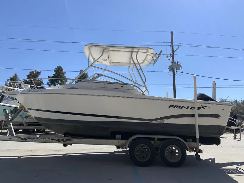Slide: The Image of 2007 Pro-Line 21 Walk boat on trailer under clear blue sky. - 4