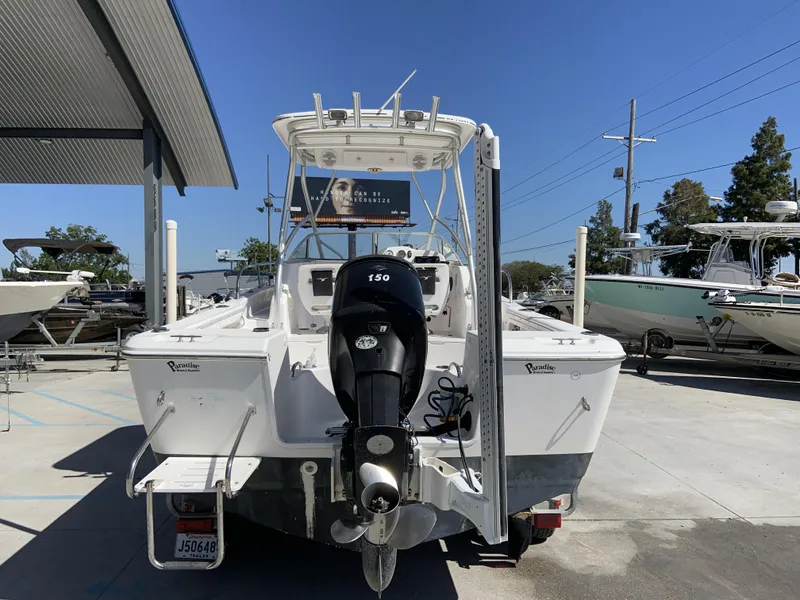 Slide: The Image of 2007 Pro-Line 21 Walk boat with outboard motor, parked in a marina under clear blue sky. - 5